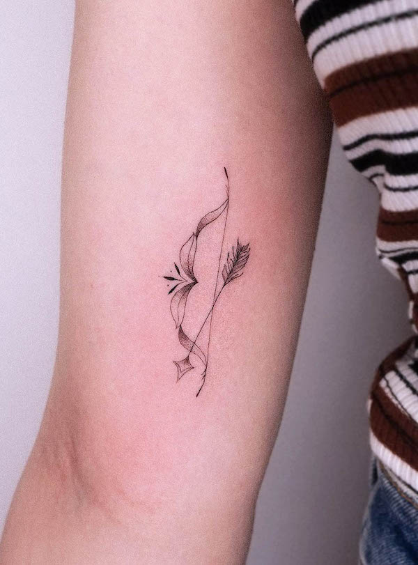 Small bow and arrow tattoo by @franzis.tatties